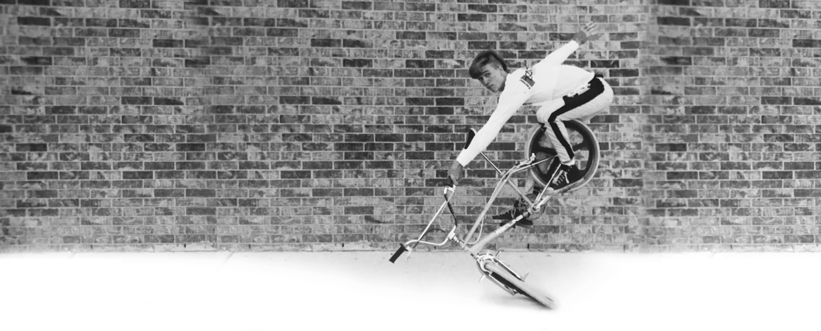 J.C. Stacy does a Miami Hopper flatland trick in front of a brick wall.